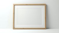 Empty wooden frame with white mat on shelf against neutral wall ready for artwork display and home decor projects.