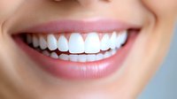 Close up of healthy white teeth and natural pink lips showing genuine smile against soft blue background. Perfect for dental and orthodontic advertising.
