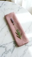 Dusty rose linen napkin with fresh lavender sprig on marble surface, perfect for table styling, event design, and home decor projects.