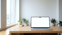 Open laptop with blank white screen on wooden desk in bright modern office workspace with plants and natural window light for productivity and remote work.