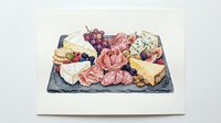 Charcuterie board with assorted cured meats, artisan cheeses, fresh grapes and crackers arranged on slate serving platter for entertaining.