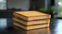 Stack of three golden brown toast slices on dark wooden table, showcasing crispy texture for breakfast food photography.