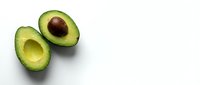Fresh ripe avocado halves with pit on clean white background isolated for healthy cooking and nutrition design projects.