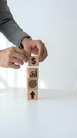 Businessman hands stacking wooden blocks with business icons showing financial growth strategy and goal achievement on white background.