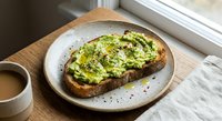 Avocado toast on sourdough bread with seeds and herbs served on ceramic plate with coffee cup for healthy breakfast meal.
