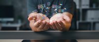 Businessman holding digital marketing icons and symbols in cupped hands, representing online business strategy and technology solutions for web development and advertising campaigns.