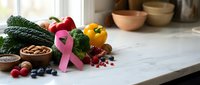 Pink ribbon with fresh vegetables and berries on kitchen counter promoting breast cancer awareness and healthy nutrition lifestyle choices.