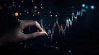 Financial market growth chart with glowing dots and human hand touching virtual trading graph display in dark blue background with orange bokeh effect.