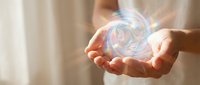 Young adult with light skin tone holding glowing holographic sphere with swirling energy patterns, representing technology, innovation, and digital transformation for futuristic business concepts.
