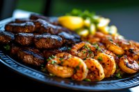Grilled surf and turf platter featuring juicy steak medallions and seasoned shrimp garnished with fresh herbs and lemon, served on dark plate with selective focus.