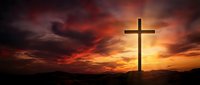 Christian cross silhouette against dramatic sunset sky with vibrant orange and red clouds creating spiritual atmosphere for religious worship and faith.