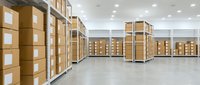Modern warehouse interior with organized cardboard boxes on metal shelving units, clean industrial storage facility for logistics and distribution operations.