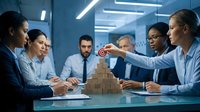 Diverse business team collaborating on strategic planning with wooden blocks in modern office conference room during corporate meeting.