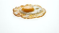 Crispy fried egg with golden yolk and lacy edges isolated on white background for breakfast menu design and culinary projects.