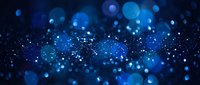 Abstract blue bokeh lights background with sparkling particles and glowing orbs creating magical atmosphere for digital design and creative projects.