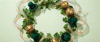 Flat lay wreath with green foliage, teal ornaments, and gold accents on pale background, isolated for holiday design projects.