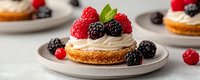 Fresh berry mini tart with whipped cream, raspberries and blackberries on gray ceramic plate. Sweet homemade dessert with crispy pastry base.