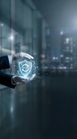 Businessman hands protecting glowing compliance shield icon with digital particles against modern office background for corporate security concepts.