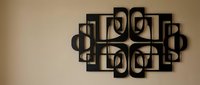 Modern geometric black metal wall art sculpture with interlocking circles and rectangles creating abstract pattern for contemporary interior design.