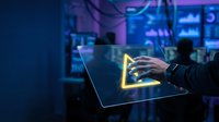Cybersecurity expert analyzing data on tablet with glowing security shield icon in modern tech control room with blue ambient lighting for digital protection.