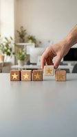 Hand placing wooden blocks with golden stars on white desk for customer rating and business feedback evaluation in modern office environment.