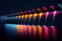 Illuminated dam spillway with colorful neon lights creating dramatic water cascades and reflections in dark water, architectural night photography for modern design.