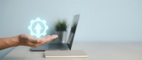 Male hand holding glowing user profile icon above laptop keyboard, representing digital identity, account management, and online user interface technology for web applications.