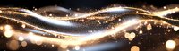 Glowing golden waves with sparkling light particles and bokeh effects flowing on dark background create magical atmosphere for festive designs.