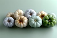 Decorative pumpkins in pastel colors of white, cream, mint green and sage arranged in a row on soft green background, creating modern autumn decor.