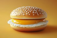 Fresh sesame seed bun with melted cheese and egg white on golden background, appetizing breakfast sandwich photographed in studio lighting.