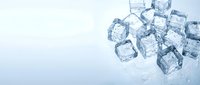 Scattered ice cubes on white surface with water droplets, suitable for beverage, refreshment, and cooling product advertising.