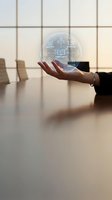 Businesswoman holding glowing holographic sphere with compliance and governance icons above conference table in modern office.