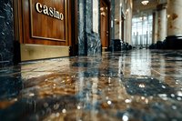 Flooded luxury casino entrance with marble floors reflecting light, showing water damage and emergency situation in upscale gambling establishment interior.