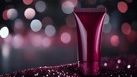 Luxurious burgundy cosmetic tube on dark background with glitter and bokeh lights creates elegant beauty product presentation for skincare or makeup advertising.
