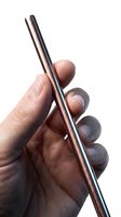 Male hand holding a shiny copper metal reusable straw on white background, eco-friendly sustainable drinking concept.