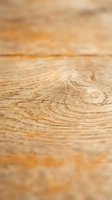 Close-up of natural wood grain texture with warm honey tones and growth rings, suitable for flooring, furniture, and interior design backgrounds.