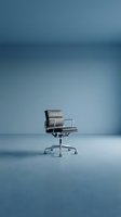 Modern gray leather office chair with aluminum frame and wheels on minimalist blue background, suitable for corporate, interior design, and furniture catalog use.