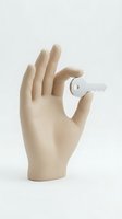 Mannequin hand holding white key on neutral background for security, real estate, access and property concepts.