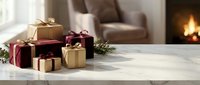 Festive gift boxes with ribbons arranged on marble table in cozy living room with fireplace creating warm holiday atmosphere for seasonal celebrations.