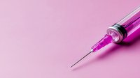 Medical syringe with pink liquid on pink background, minimalist healthcare concept with copy space for pharmaceutical and vaccination designs.