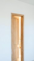 Open wooden door with natural light streaming through, isolated on white background, suitable for interior design, architecture, real estate, and home renovation projects.
