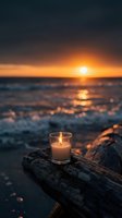 Glowing candle on driftwood at ocean sunset with golden light reflecting on waves creating peaceful romantic atmosphere for meditation and relaxation.