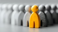 Yellow wooden figure standing out from crowd of gray figures, concept of individuality, leadership, and uniqueness in business or social environment.
