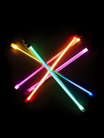 Colorful glowing neon tubes arranged in crossed pattern against black background creating vibrant abstract composition with red, blue, green, yellow and pink light effects.
