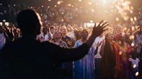 Large diverse crowd worshipping at a church event, hands raised in praise, glowing golden light, spiritual atmosphere of unity and faith.