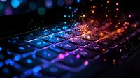 Illuminated computer keyboard with colorful glowing particles floating above keys creating magical gradient effect from blue to orange, perfect for technology concepts.