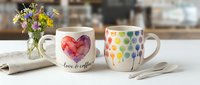 Love is coffee, heart design on ceramic mug with colorful polka dot mug, fresh flowers in vase, perfect for café, kitchen, lifestyle, and product photography.