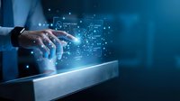 Businessman hand touching digital tablet with glowing data network and technology icons flowing from screen, representing cloud computing, data transfer, and digital innovation for business solutions.