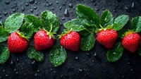 Fresh ripe strawberries with green leaves and water drops on dark background, arranged in line. Natural organic berries with morning dew for healthy eating.