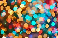 Vibrant defocused bokeh lights creating magical abstract background in gold, turquoise and coral colors. Festive blurred circles pattern for holiday designs.